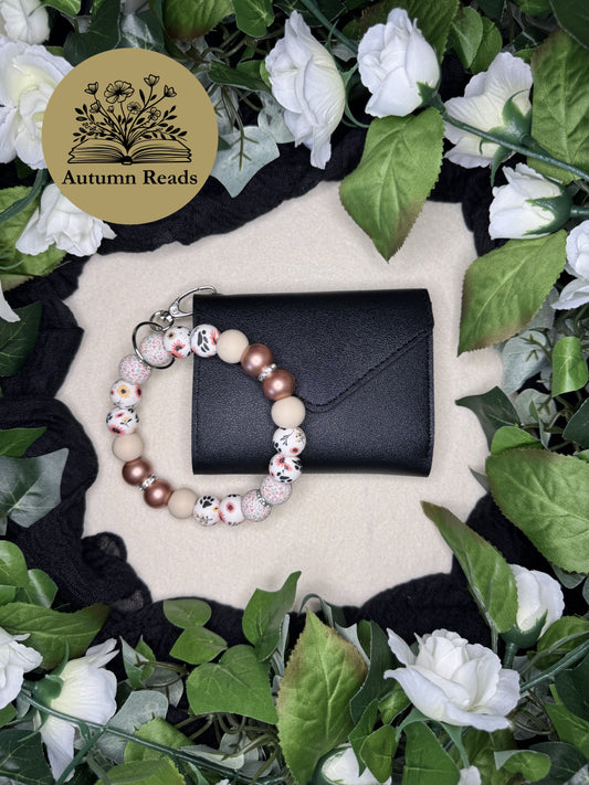 Becca’s Out for a Walk handmade beaded keychain paired with a black faux leather wallet by Autumn Reads LLC